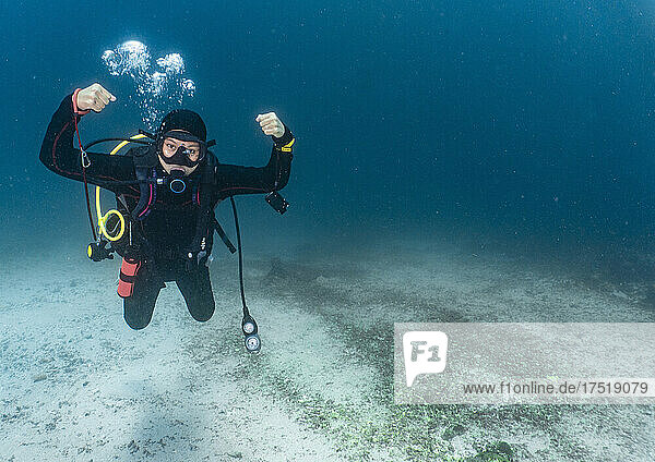 scuba diver posing in the tropical waters around Komodo