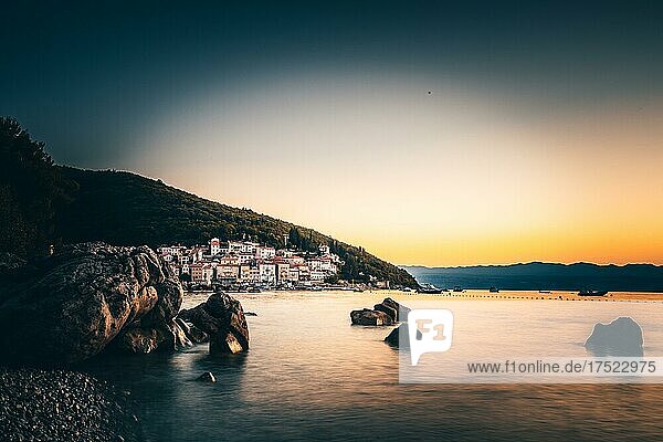 Langzeitbelichtung mit Felsen im Meer und einem Mediteranen Fischerdorf im Hintergrund  Istrien  Kvarner Bucht  Kroatische Adria  Kroatien  Europa
