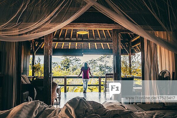 Blick aus einem Himmelbett in die Morgenstimmung  Hotel Bungalow aus Holz in den Reisfeldern von Sidemen  Bali  Indonesien  Asien