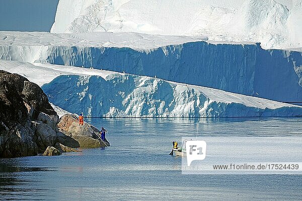 Boot vor riesigem Eisberg  Fischer stehen auf Felsen  Diskobucht  Sermermuit  Ilulissat  Arktis  Grönland  Dänemark  Nordamerika
