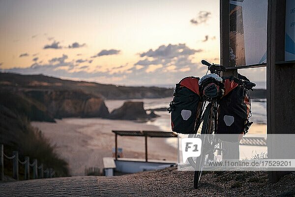 Fahrrad mit Taschen am Strand von Almograve bei Sonnenuntergang  Alentejo  Portugal  Europa