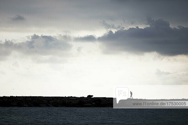 Person backlit on coastal fortification in San Lorenzo al Mare  Liguria  Italy  Europe