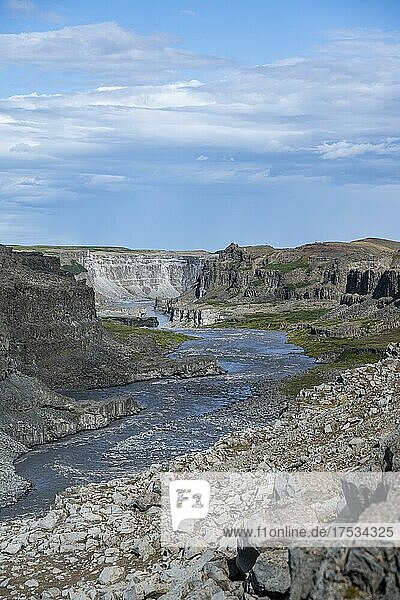 Frau steht vor Schlucht  Canyon mit herabstürzenden Wassermassen  Dettifoss Wasserfall im Sommer  Nordisland  Island  Europa