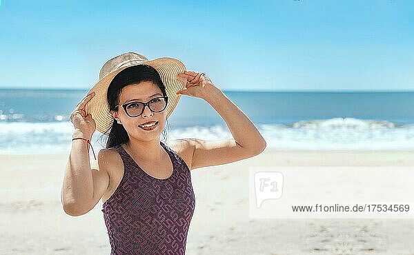 Frau in Hut glücklich am Strand  glücklich hübsche junge Frau im Urlaub  Urlaub Konzept