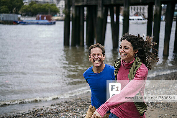 Cheerful couple enjoying at Thames riverbank  London  England