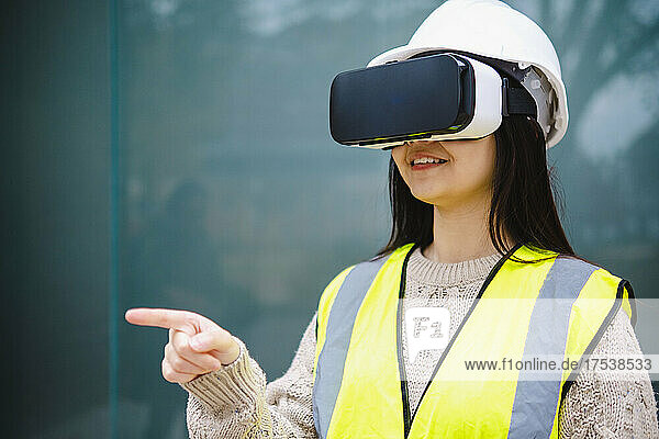 Young architect with virtual reality headset and pointing