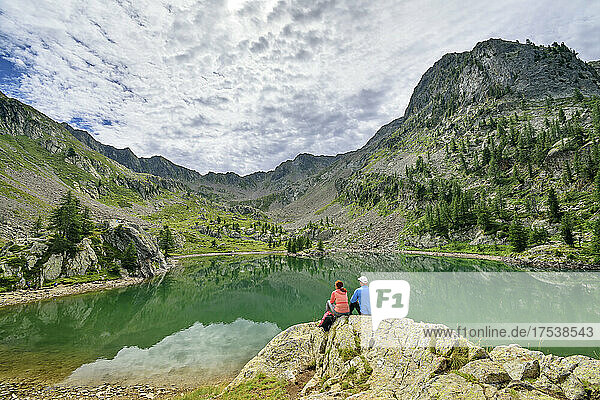 Tourists looking at Lac de Trecolpas lake Mercantour National Park  France