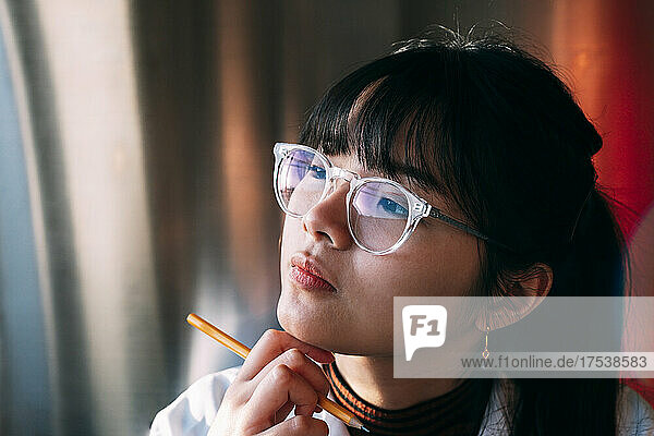 Young chemist wearing eyeglasses contemplating in laboratory