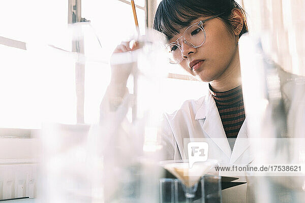 Young chemist working with concentration in laboratory