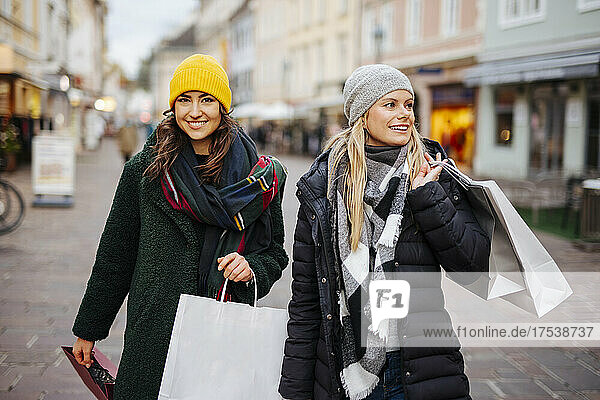 Happy friends enjoying shopping at Christmas Market