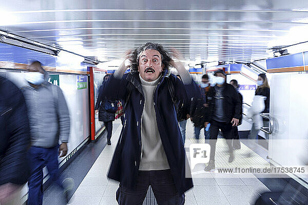 Shocked man standing at subway station