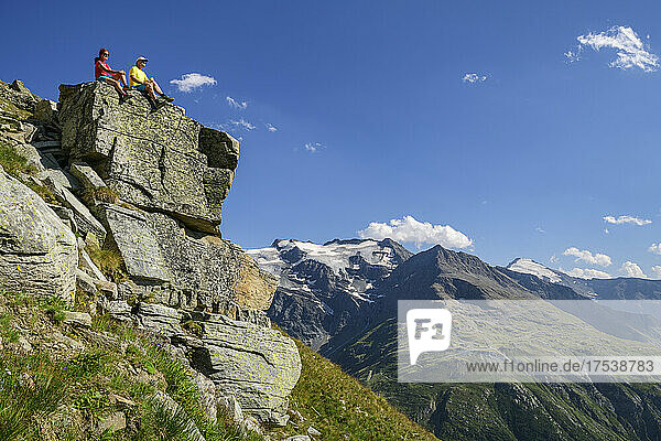 Hikers sitting on top of cliff at sunny day Vanoise Massif  Vanoise National Park  France