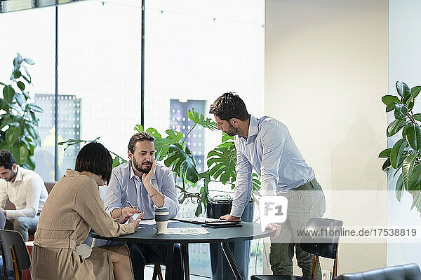 Business colleagues discussing at table in office