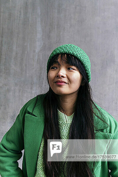 Young woman wearing green winter coat and knit hat