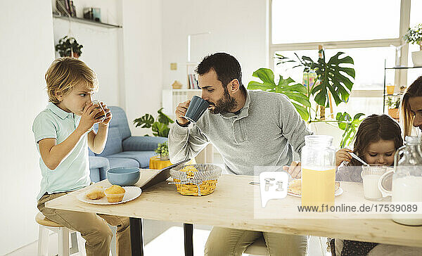 Father and son having drinks at table