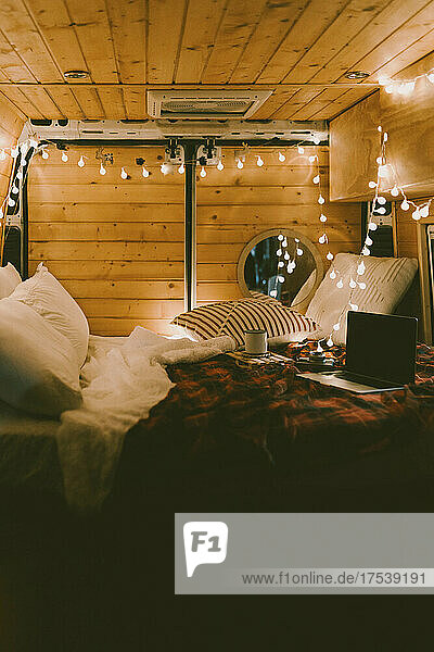 Laptop on bed in illuminated motor home