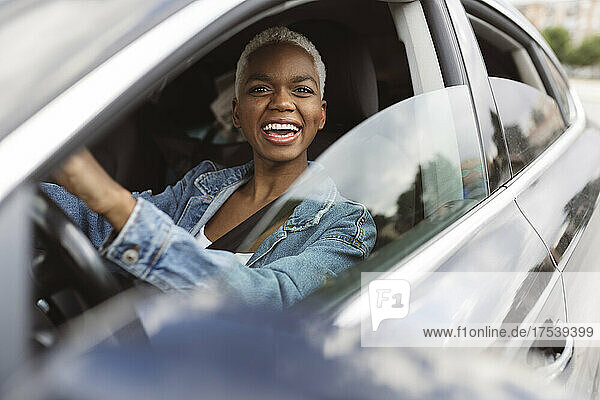 Happy young woman sitting in car