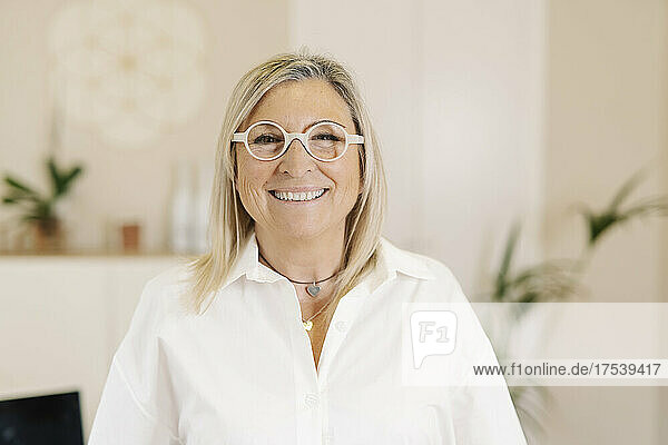Glückliche Geschäftsfrau mit Brille im Büro