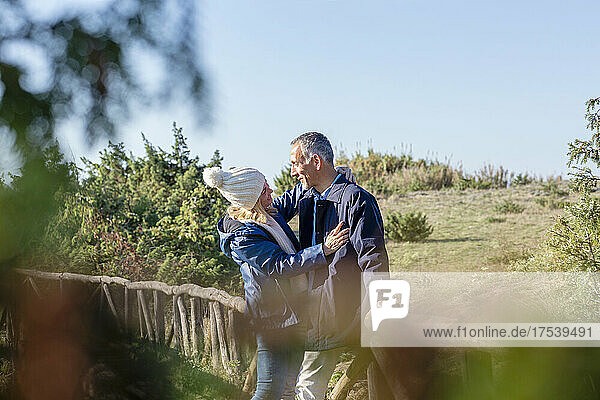 Affectionate couple standing on wooden bridge