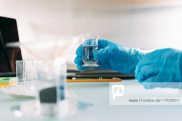 Young working with liquid solution in glassware