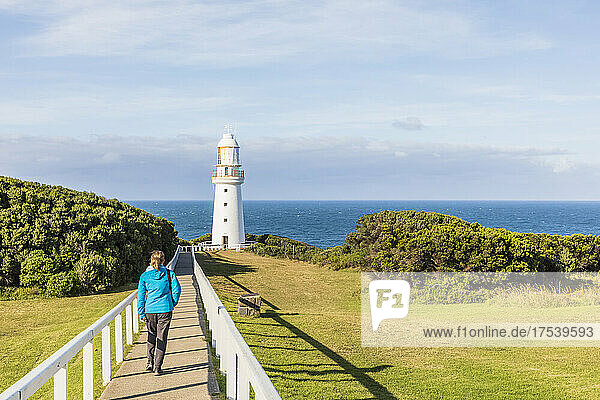 Australia  Victoria  Cape Otway  Female tourist walking along footpath leading to Cape Otway Lighthouse in Great Otway National Park