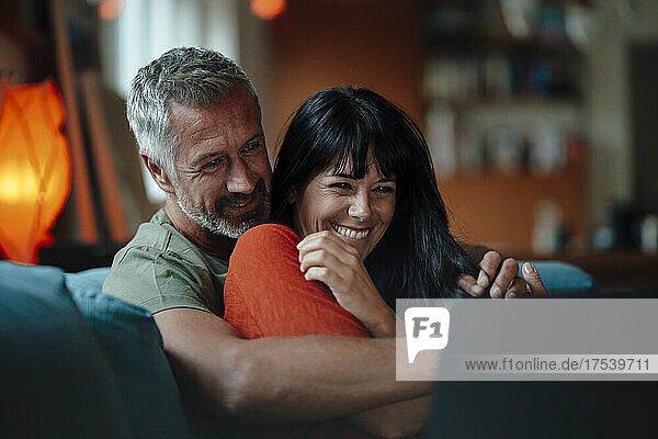 Happy mature couple using tablet PC in living room