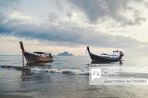 Longtail boats moored in sea at Ao Nang beach  Krabi Province  Thailand