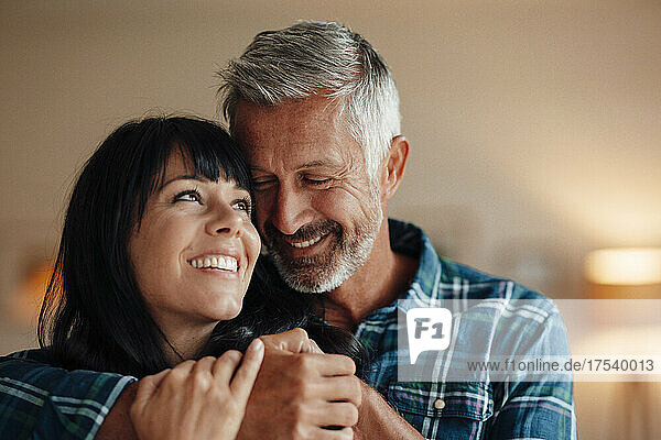 Smiling couple embracing at home