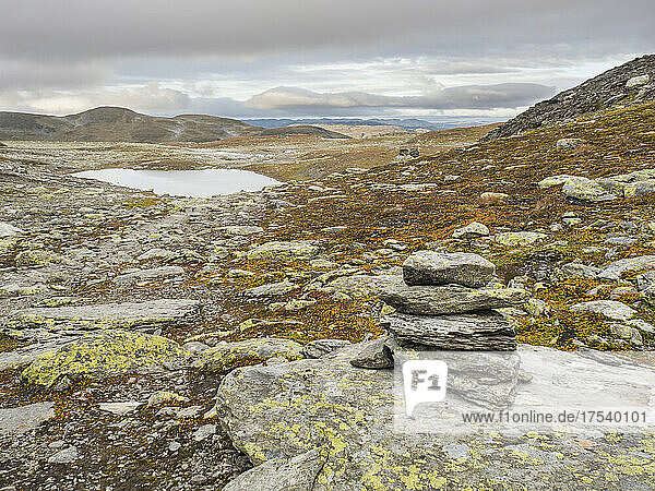 Small cairn at Hardangervidda plateau with lake in background