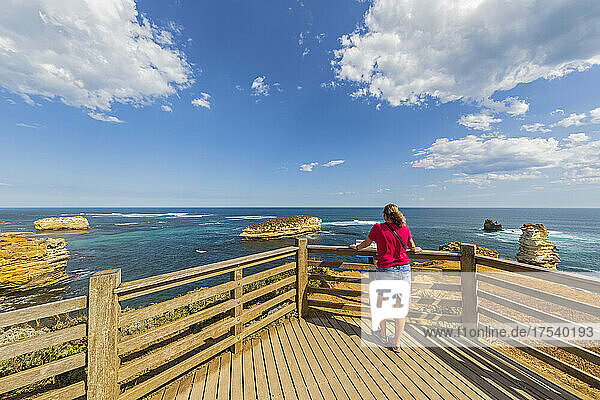 Australien  Victoria  weibliche Touristin  die die Bay of Islands von der Aussichtsplattform aus bewundert