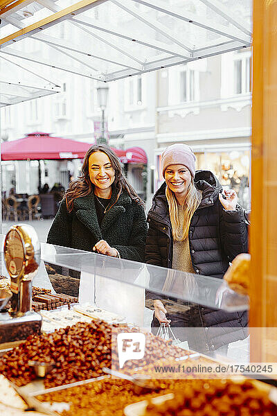Smiling women buying sweets at Christmas Market