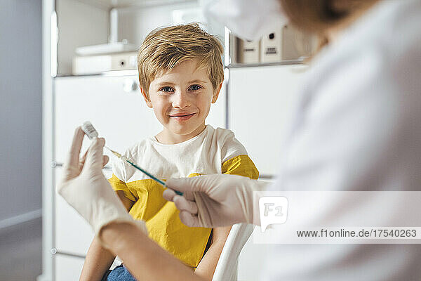 Smiling boy with doctor at vaccination center