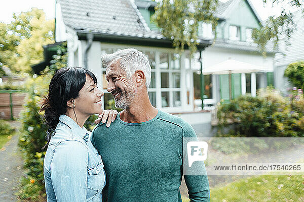 Smiling mature couple looking at each other in backyard