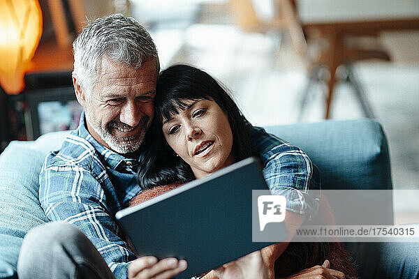 Mature couple using tablet PC at home