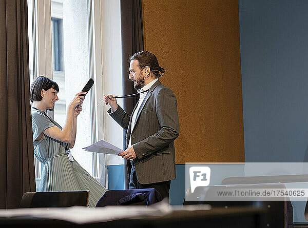 Businesswoman scanning identity card of colleague through tablet PC