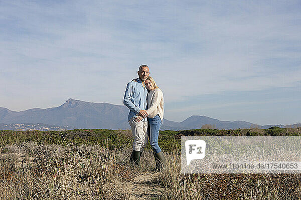 Romantic couple standing together at dunes