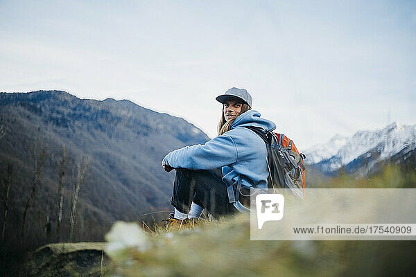 Smiling backpacker with cap and backpack on vacation
