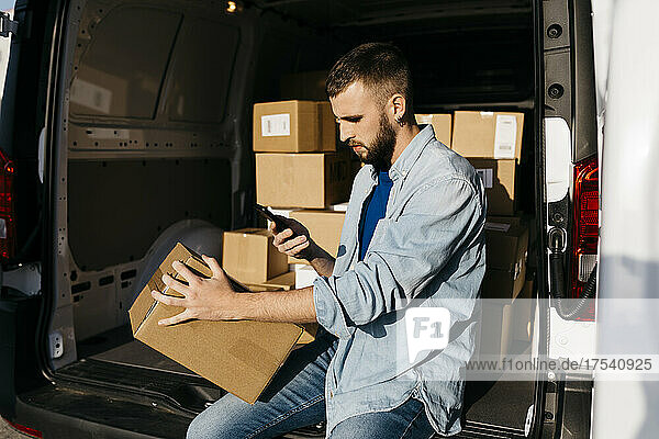 Delivery person scanning package in van