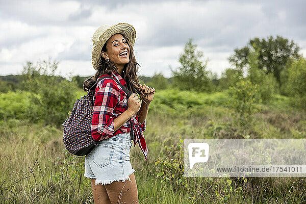 Cheerful woman with hat and backpack at Cannock Chase