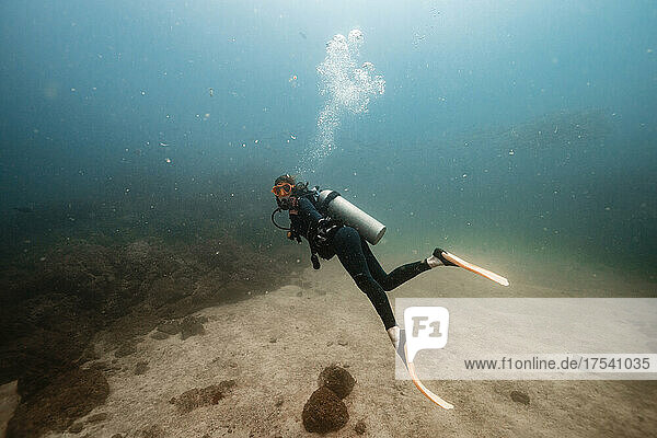 Scuba diver swimming underwater at Del Coco beach