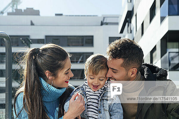 Smiling mother and father with baby boy on sunny day