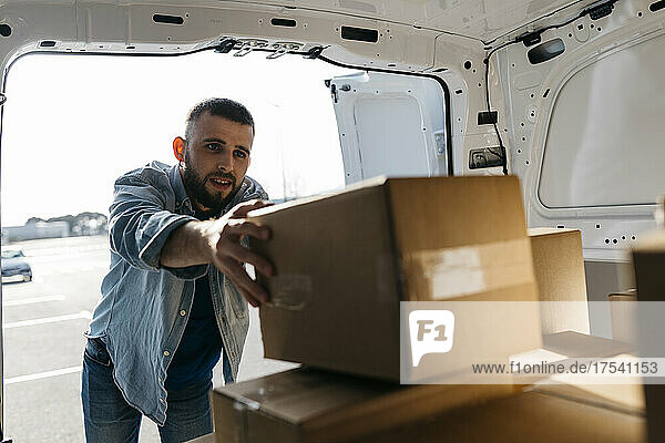 Delivery man arranging boxes in van
