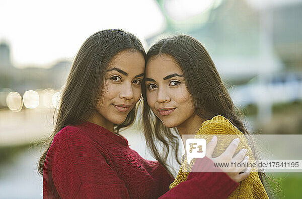 Beautiful sisters smiling and embracing