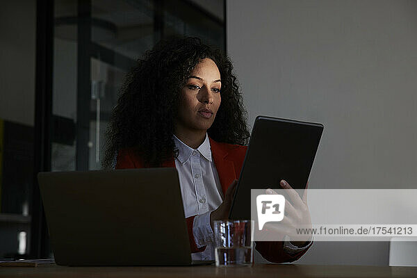 Confident businesswoman working on tablet PC in office