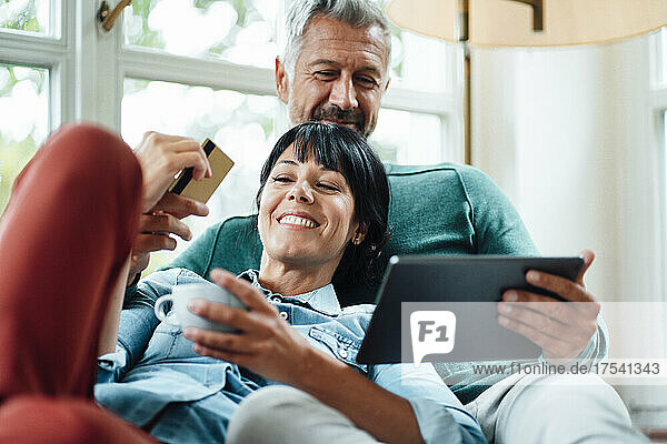 Happy couple with credit card doing online shopping on Tablet PC