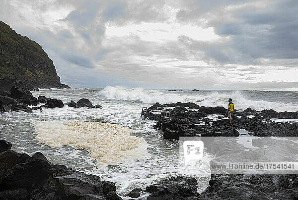 Man standing on rocks near thermal pool at Ponta da Ferraria  San Miguel  Azores  Portugal