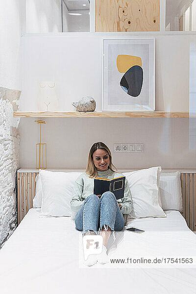 Frau liest zu Hause im Bett ein Buch