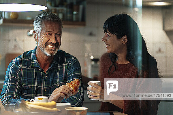 Happy mature couple having food in kitchen