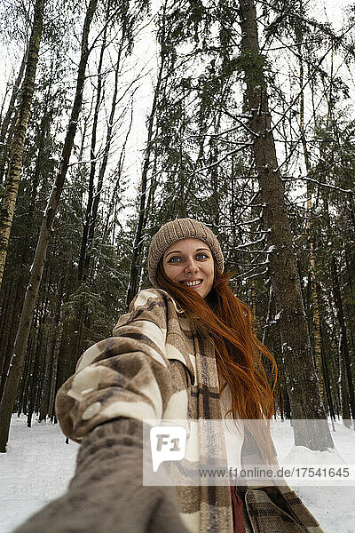 Smiling woman in winter forest on vacation