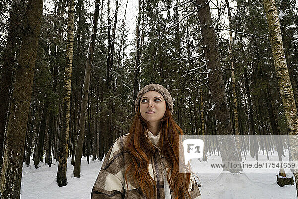 Woman on vacation day dreaming in winter forest